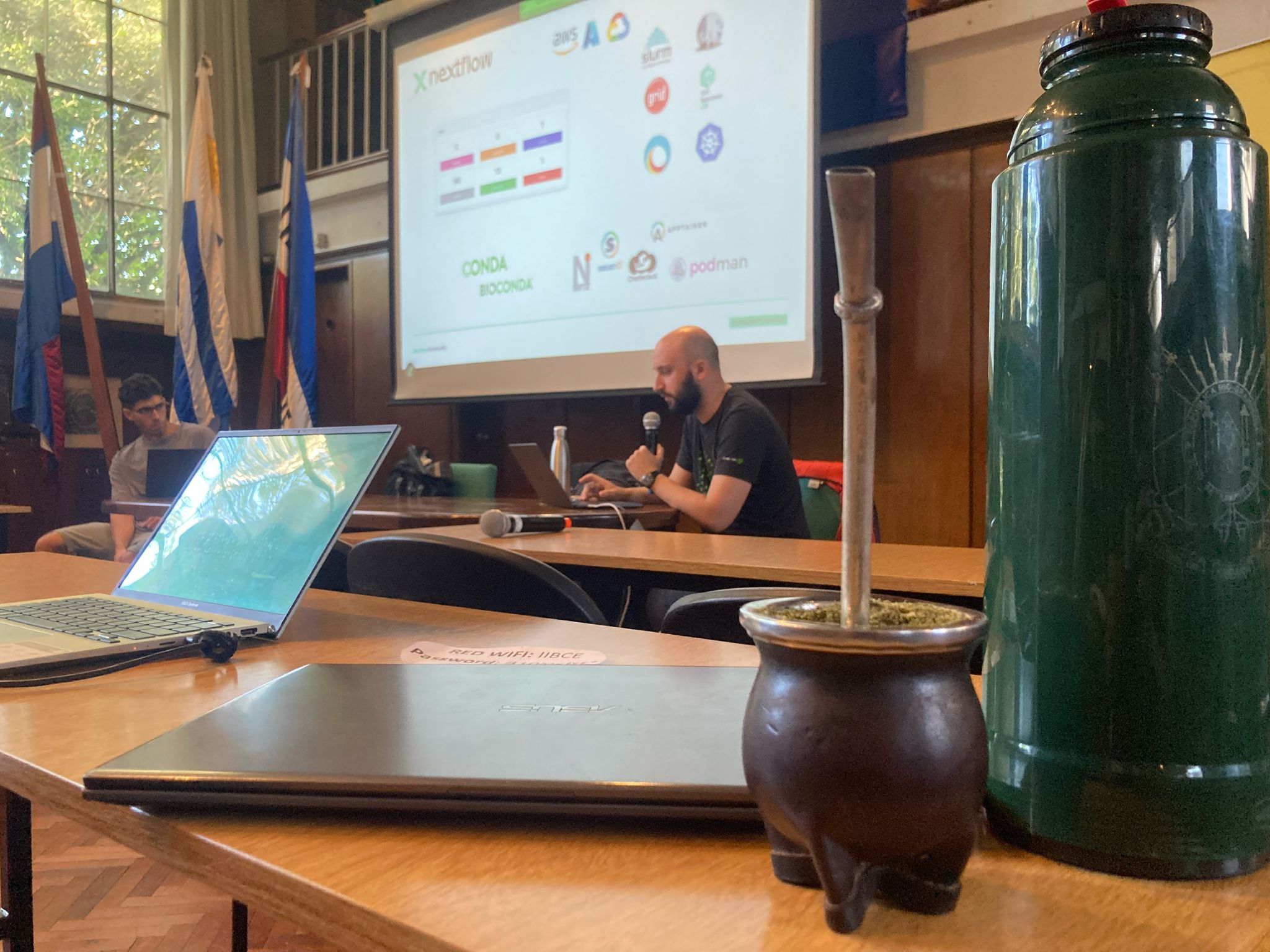 A picture of shared monitor with a mate drink and a flask in the front plane.